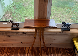 Charming three-legged accent table with curvy legs coated in varnish.